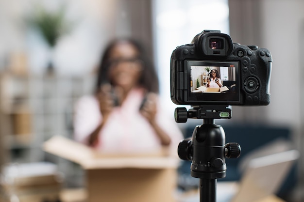 Foto blogueira africana fazendo transmissão ao vivo enquanto desembala a caixa