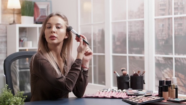 Blogueira de beleza fazendo um tutorial online sobre maquiagem e mostrando como fazer