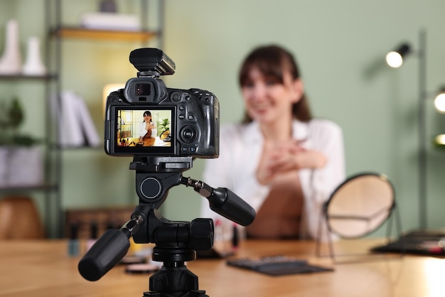 Blogueira de beleza gravando vídeo em casa focando na câmera