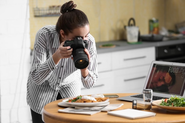 Foto blogueira de culinária tirando foto de seu almoço em uma mesa de madeira dentro de casa