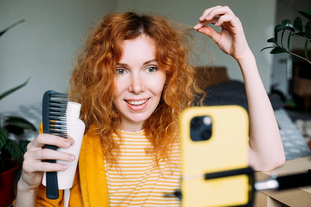 Foto blogueira ruiva transmite ao vivo críticas de produtos de beleza para o cabelo