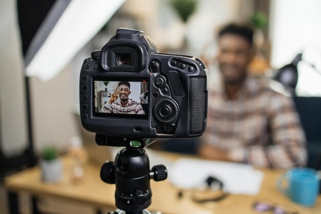 Foto blogueiro afro-americano usando câmera de vídeo para trabalhar