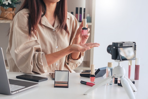 Blogueiro de beleza gravando vídeo e apresentando cosméticos em casa