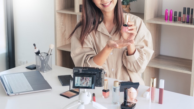 Blogueiro de beleza gravando vídeo e apresentando cosméticos em casa