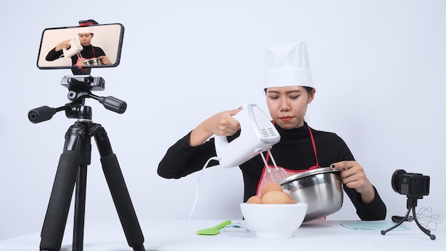 Blogueiro de comida transmitindo ao vivo. Chef mulher instrutor de comida online. Cozinhar com assinantes por meio da câmera do telefone online.