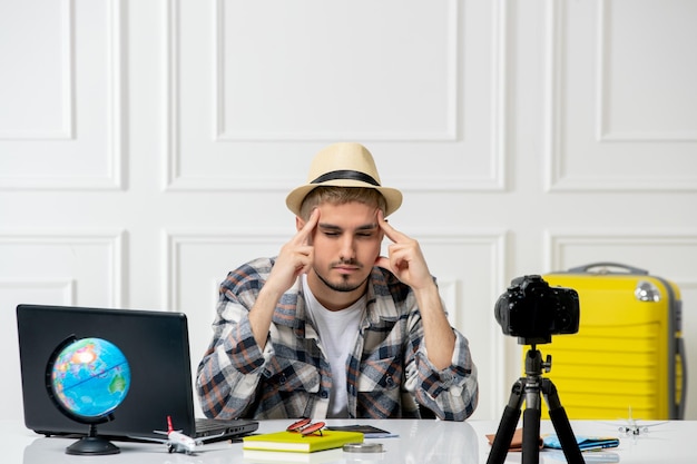 Blogueiro de viagens usando chapéu de palha jovem bonitão gravando vlog de viagem na câmera cansado