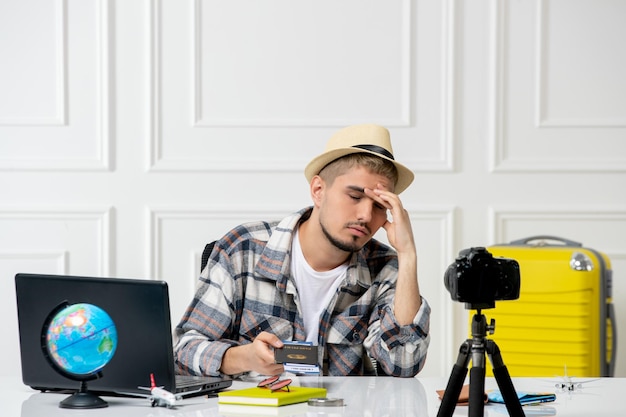 Blogueiro de viagens usando chapéu de palha jovem bonitão gravando vlog de viagem na câmera entediado