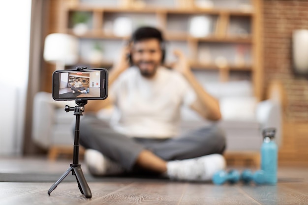 Blogueiro fitness gravando vídeo para vlog esportivo no telefone