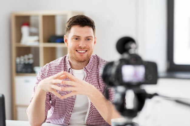 Foto blogueiro masculino com câmera videoblogging em casa