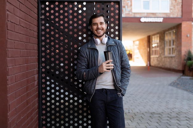 Blogueiro masculino europeu sorridente ao ar livre em roupas de primavera