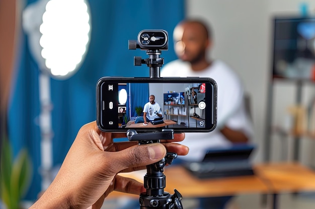 Foto blogueiro prepara telefone celular para fazer uma gravação ao vivo