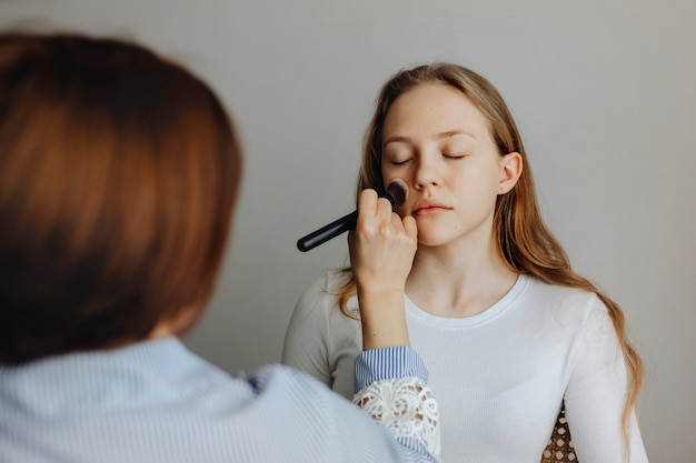 Bloguera de belleza aplicando base líquida a su modelo