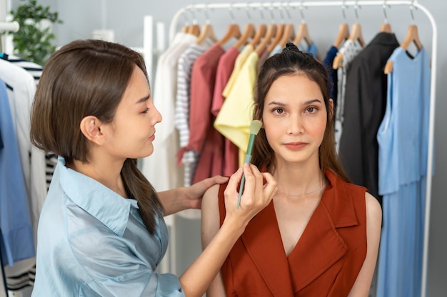 Una bloguera de belleza tailandesa transmite en vivo una revisión de productos cosméticos con una modelo asiática. Curso online de tutorial de influencers en home studio.