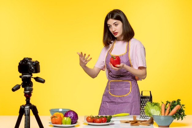 Bloguera de comida linda cocinera fitness grabando video para redes sociales con pimiento rojo