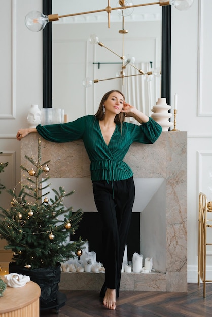 Una bloguera elegante celebra la Navidad en un interior clásico