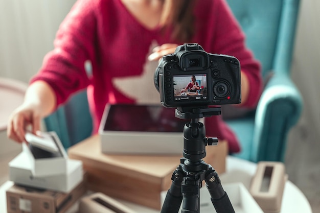 La bloguera de la pantalla de la cámara de primer plano hace un video de desempaquetar dispositivos en casa