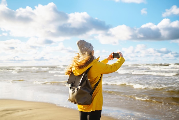 Una bloguera de viajes se toma una selfie para las redes sociales al atardecer en el mar Concepto de turismo de viaje y relajación