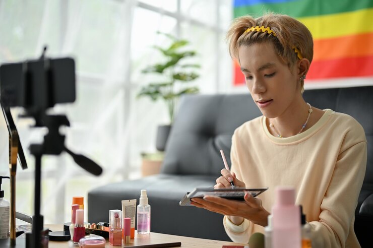 Foto un bloguero de belleza o maquillador gay está revisando sus productos de belleza en video