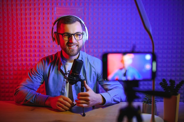 Un bloguero de video graba contenido en su estudio. La foto detrás del escenario fue tomada desde atrás de uno de los participantes en el rodaje al comienzo del rodaje cuando el bloguero se está preparando.