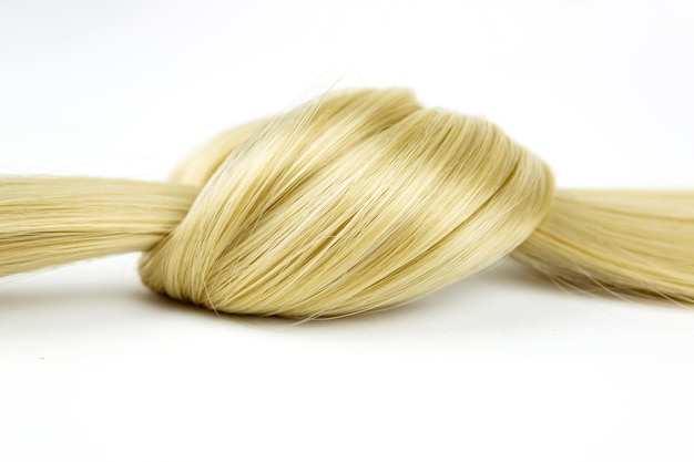 Blond gewelltes Haar Lock in Knoten auf weißem Hintergrund gebunden Stück blondes Haar Lock in Knoten auf weißem Hintergrund gebunden