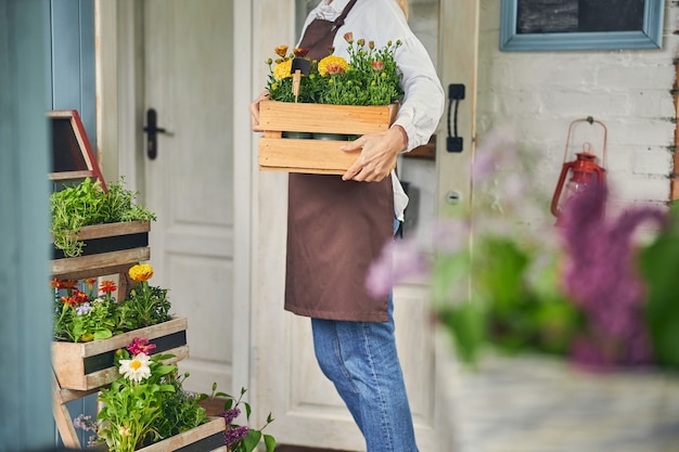 Blonde Botanikerin mit Ringelblumen und Gazanias