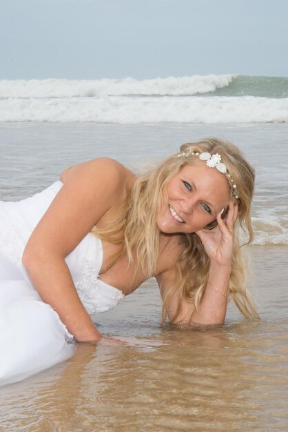 Blonde Brautfrau am Strand zur Sommerzeit