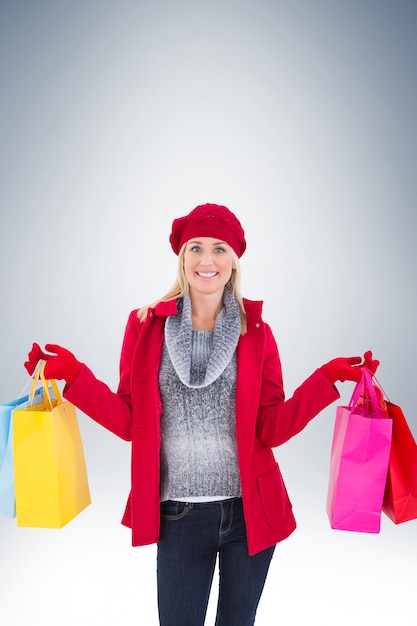Blonde em roupas de inverno segurando sacolas de compras