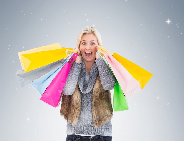 Blonde em roupas de inverno segurando sacolas de compras