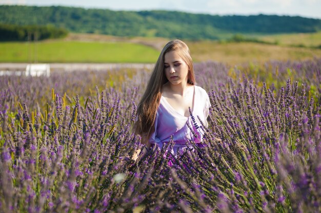 Blonde Frau auf dem Gartenfeld im Sommer