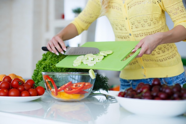 Blonde Frau bereitet Salat in der Küche zu