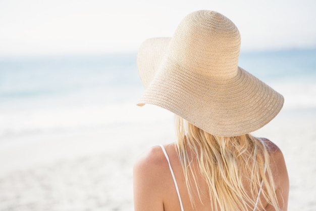 Blonde Frau, die am Strand aufwirft