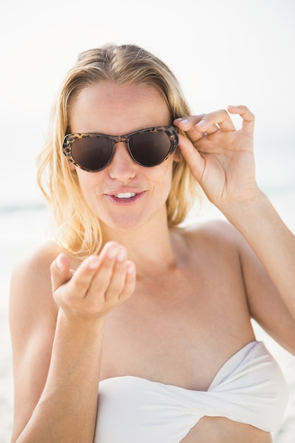 Blonde Frau, die am Strand aufwirft