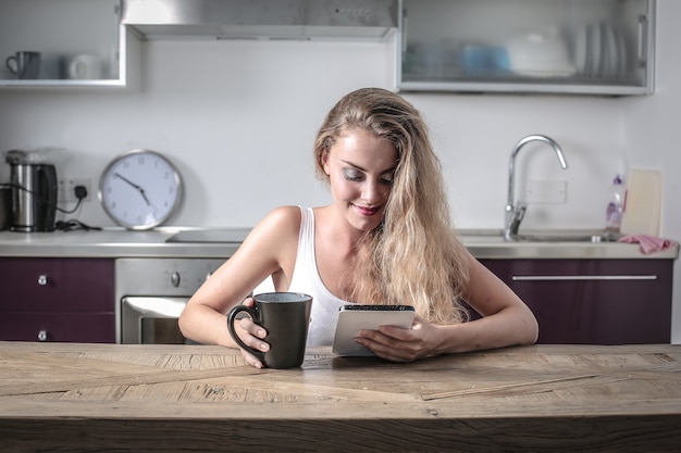 Blonde Frau, die eine Tablette verwendet