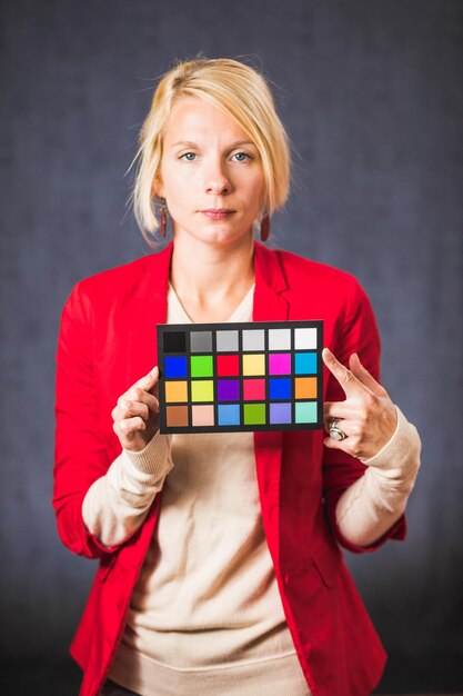 Foto blonde frau, die farbtafel hält