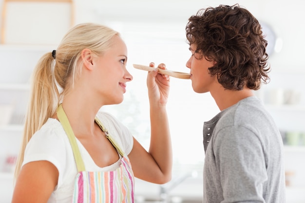 Blonde Frau, die ihr Verlobtes schmeckt ihre Mahlzeit macht