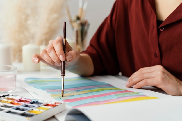 Blonde frau, die mit aquarellen malt