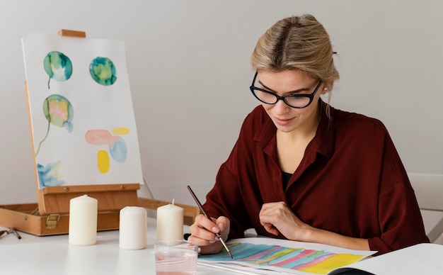 Foto blonde frau, die mit aquarellen malt