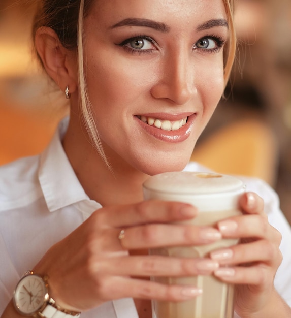 Blonde Frau, die morgens im Restaurant Kaffee trinkt