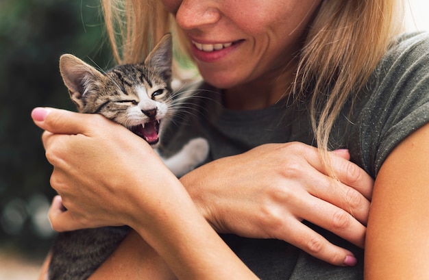 Blonde Frau, die niedliche kleine Katze hält