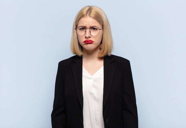 Blonde Frau, die traurig und weinerlich mit einem unglücklichen Blick ist und mit einer negativen und frustrierten Einstellung weint