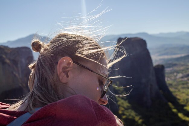 Foto blonde frau genießt malerische berglandschaft mit fokus auf den vordergrund