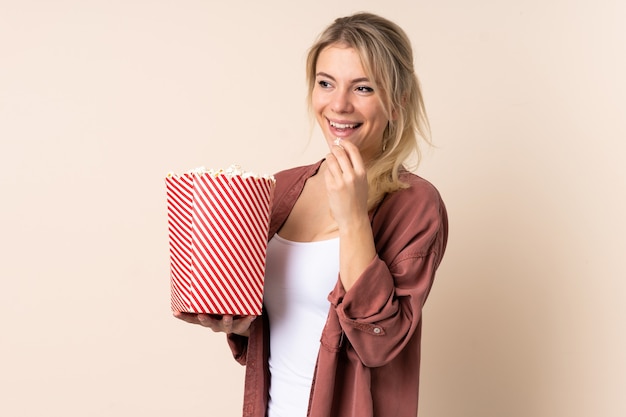 Blonde Frau hält einen großen Eimer Popcorn