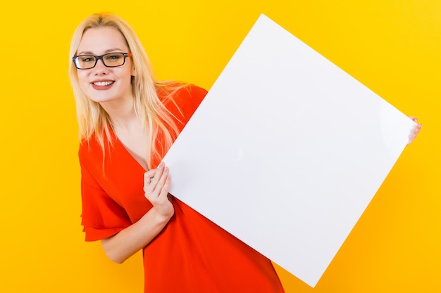 Blonde Frau im Kleid mit leerem Papier