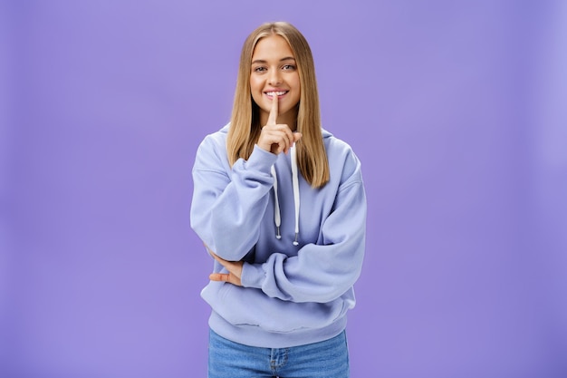 Blonde Frau mit blauem Pullover über Veilchen