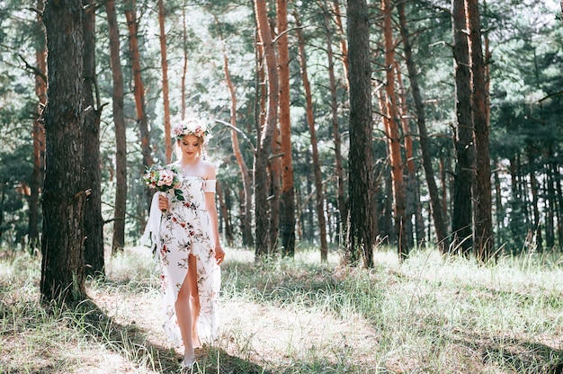 blonde Frau mit Blumenart in einem grünen Wald