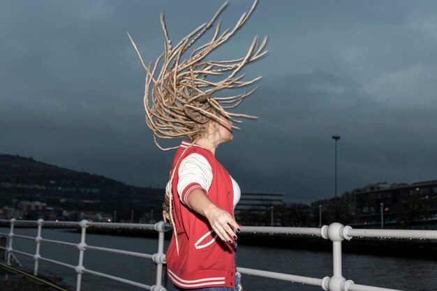 Foto blonde frau mit dreadlocks, die mit ihren haaren schüttelt