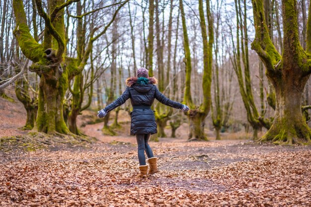 blonde Frau mit einem langen Mantel in einem Wald