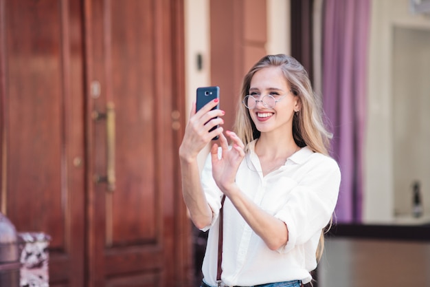 Blonde Frau mit einem Smartphone