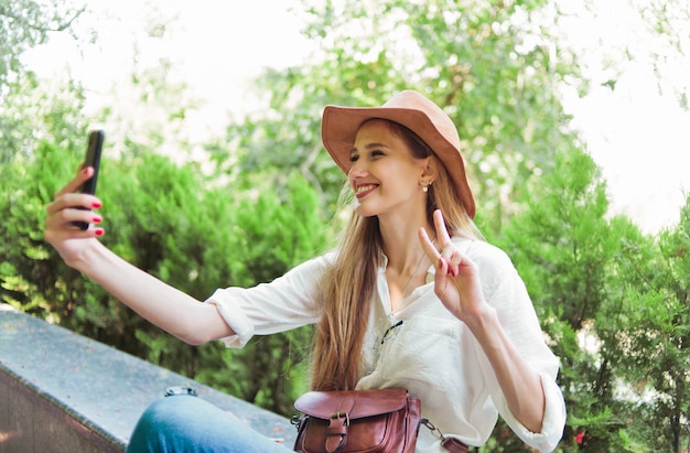 Blonde Frau mit einem Smartphone