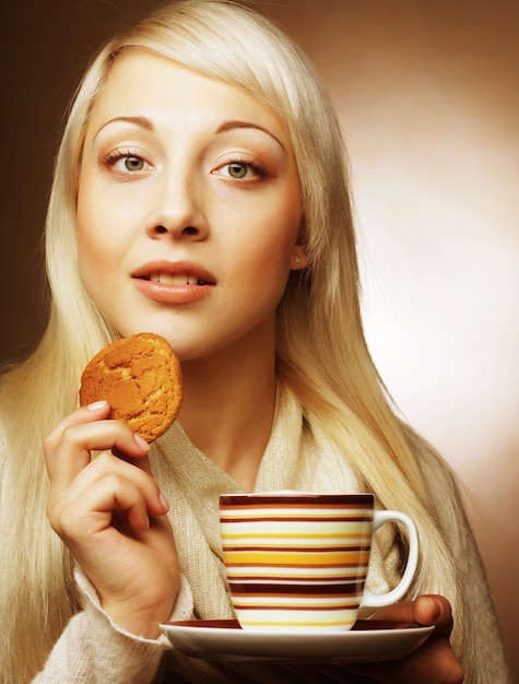 Blonde Frau mit Kaffee und Keksen